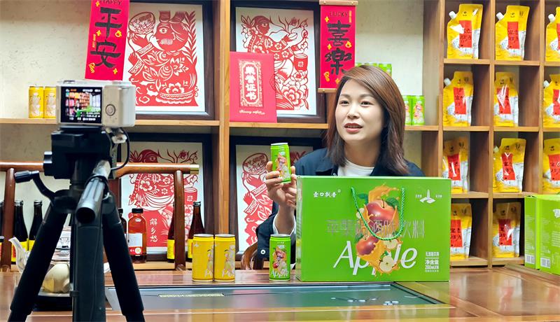 主播袁倩正通过镜头，向全国网友热情推介“苹果稠酒味饮料”。_proc.jpg